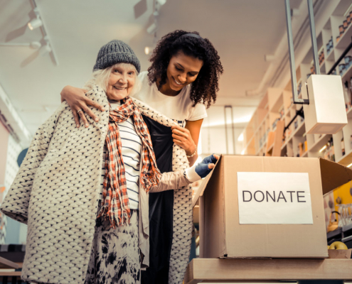 A women donating here coat during a coat drive