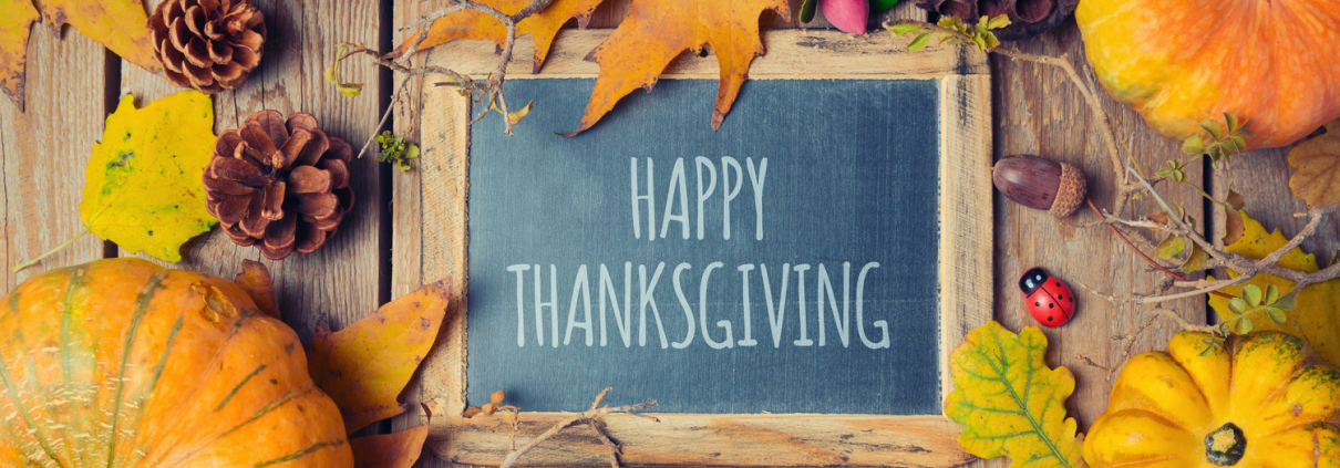 Thanksgiving background with chalkboard. Autumn pumpkin and fall leaves on wooden table. View from above