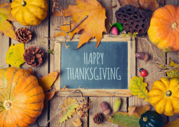 Thanksgiving background with chalkboard. Autumn pumpkin and fall leaves on wooden table. View from above