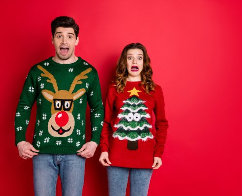 Two people wearing ugly Christmas sweaters