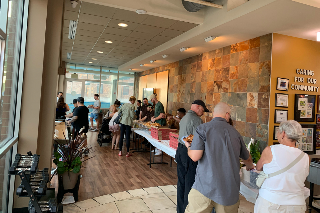 Member grabbing pizza at Appreciation Week party at Best Gym in Oak Park.