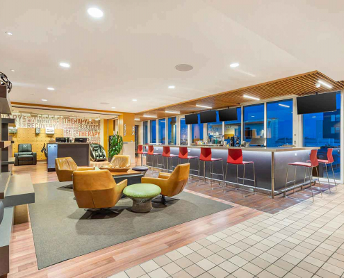 Club Lounge with full-service bar, fireplace and seating area inside Elmhurst Gym.