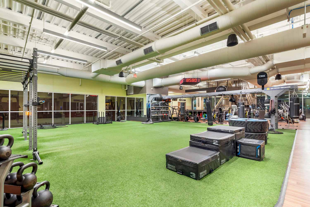 Indoor turf with strength and cardio equipment at FFC Elmhurst gym.