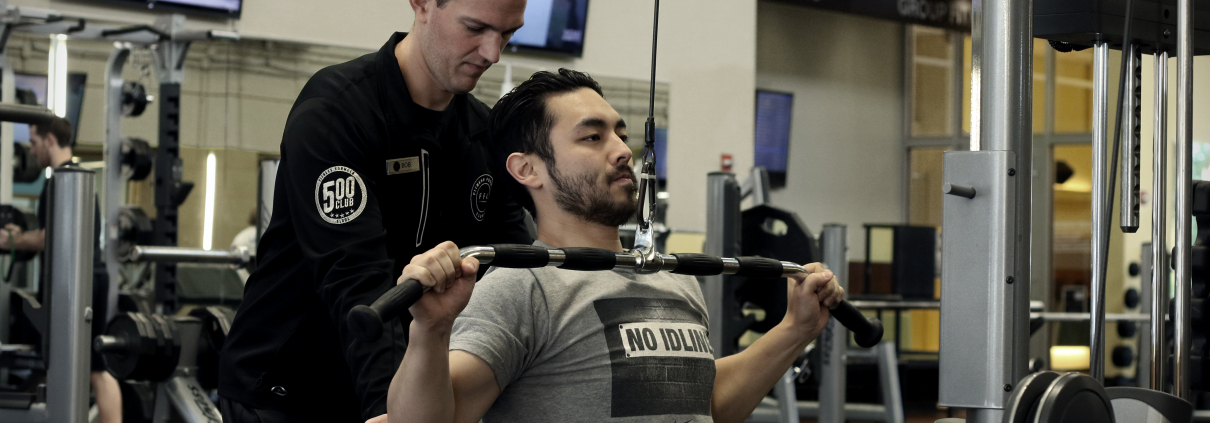 Personal trainer helping his client with his lateral pulldown workout at FFC West Loop.jpg