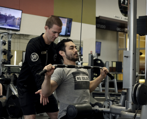 Personal trainer helping his client with his lateral pulldown workout at FFC West Loop.jpg
