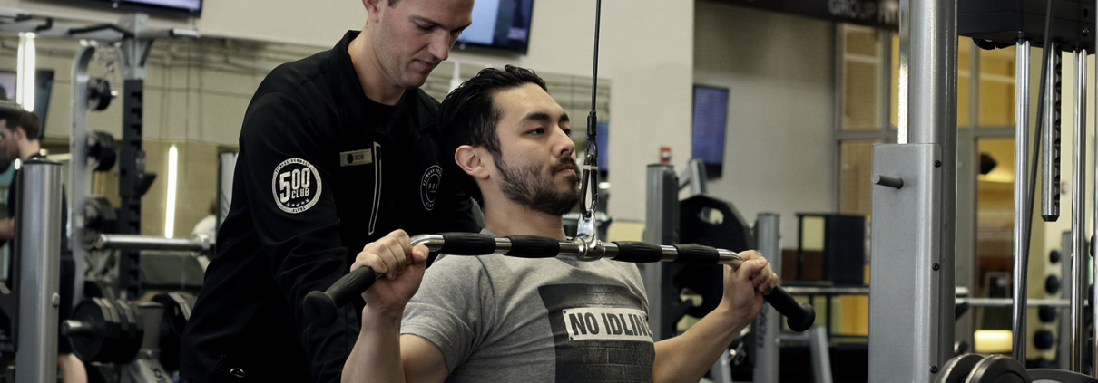 Personal Trainer assisting client at FFC West Loop