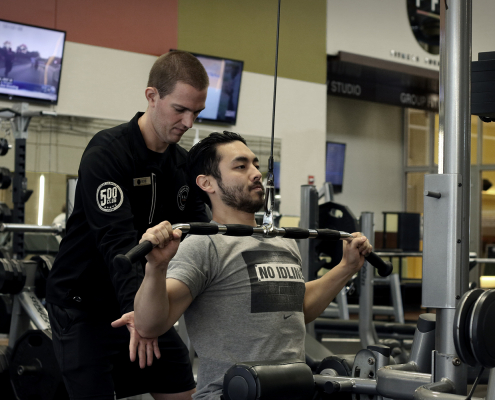 Personal Trainer assisting client at FFC West Loop