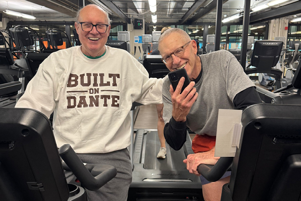 Two Gold Coast Members on the bicycle machine smiling