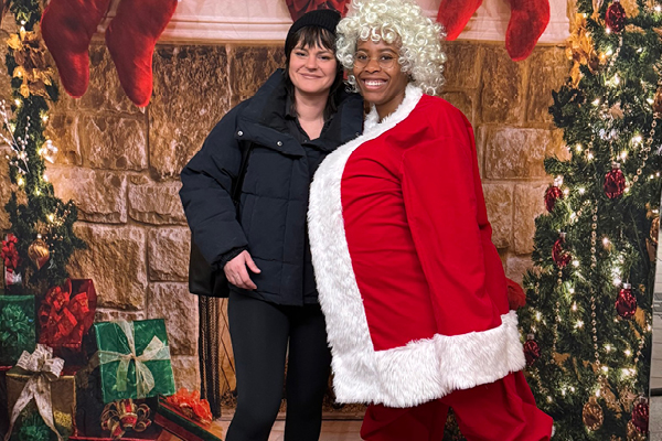 FFC Gold Coast employee dressed as Santa Claus posed with member with fireplace backsplash