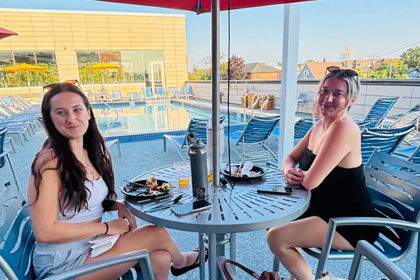Two ffc park ridge members sitting on the pool deck with food